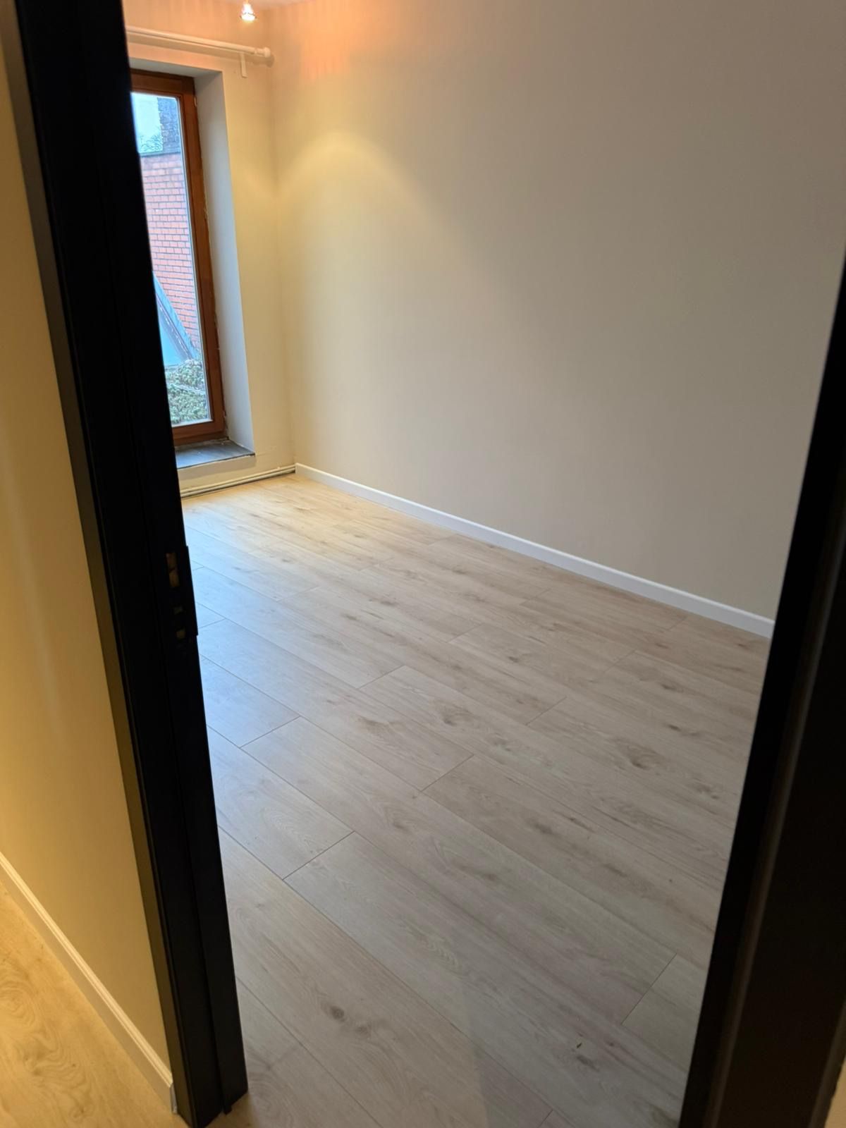 Opgeleverde kamer met strakke lichte wanden en een nieuwe lichte vloer